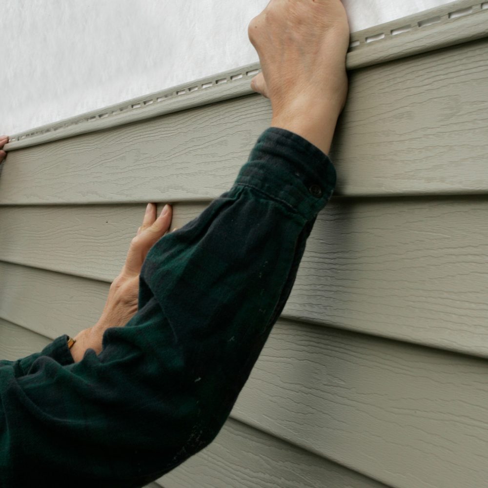 professionals installing siding on home
